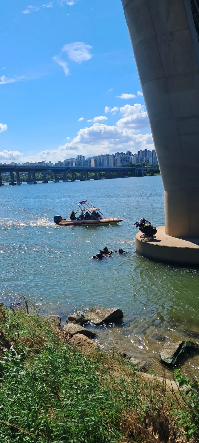다리 아래 보트와 잠수 대원